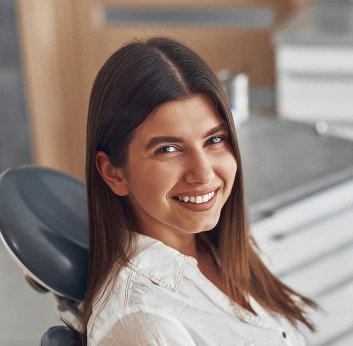 Smiling woman seated in the dental chair at Troy Meadows Dental
